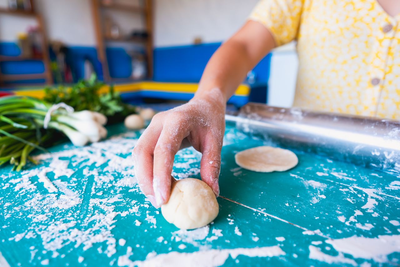 The Art of Drawing Readers In: Your attractive post title goes here A person preparing dough by hand in a colorful kitchen setting. Ideal for cooking or baking themes.